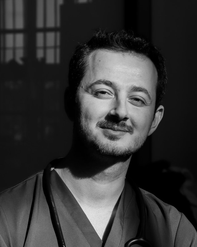 Dr. Alperen Mert Çetin, önlük ve stetoskopla